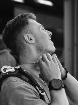 Esteban, in a skydiving harness, looking up